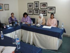 Tahreem Fatima and Saba Zaman sitting between the APWA officials for Evaluation